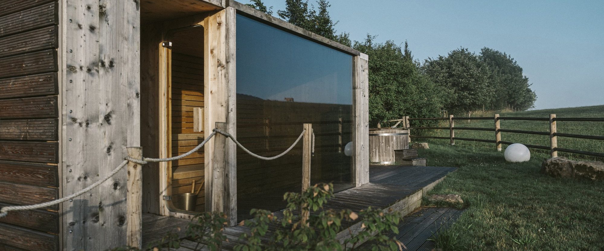 Venkovní sauna s prosklenou stěnou u pastviny